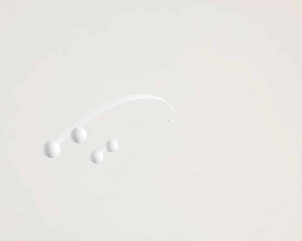 High-speed photography of various golf ball flight patterns against a plain, neutral background. Capture the smooth, parabolic trajectories of the balls as they arc through the air, with crisp details and accurate proportions. Use a fast shutter speed to freeze the motion, and a telephoto lens to isolate the subjects. Ensure consistent, natural lighting to create a clean, professional look. Maintain a shallow depth of field to emphasize the ball flight while softening the background. The resulting image should clearly demonstrate the different shot shapes and trajectories referenced in the "Types of Ball Flight Patterns" section, providing a visually compelling illustration for the article.